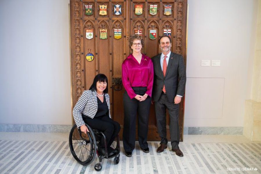 Senator Marnie McBean, centre, is welcomed to the Senate by Senator Chantal Petitclerc (left) and Senator Marc Gold (right).